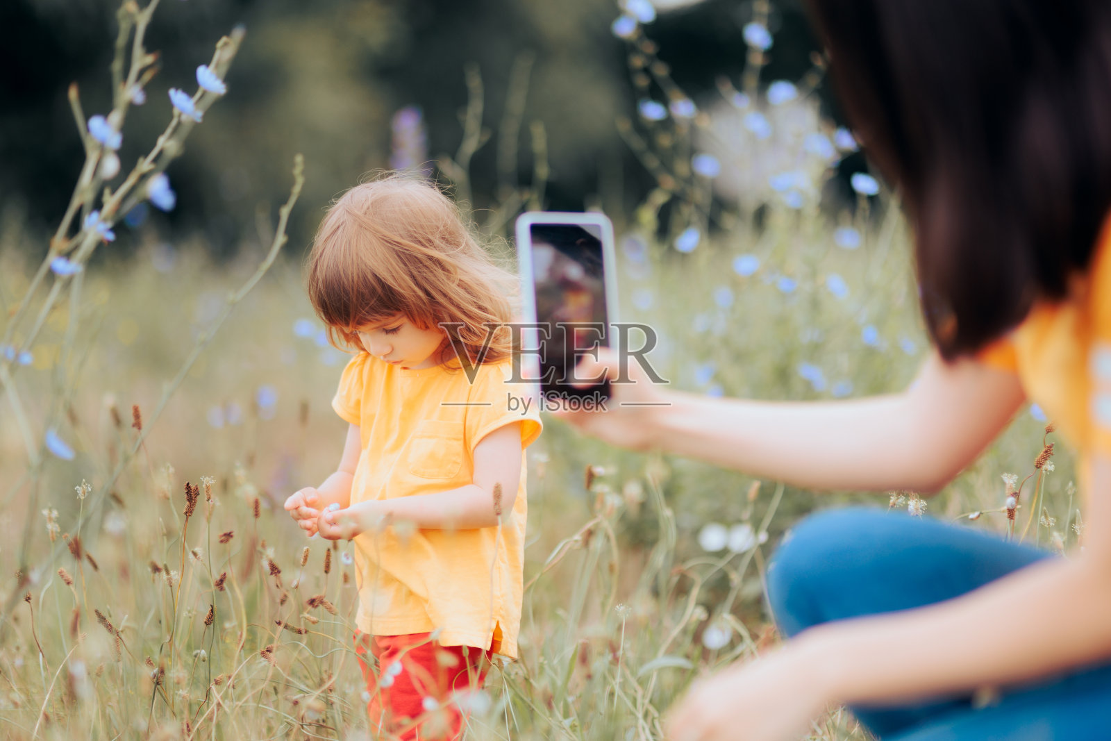 母亲在拍女儿在大自然中玩耍的照片照片摄影图片