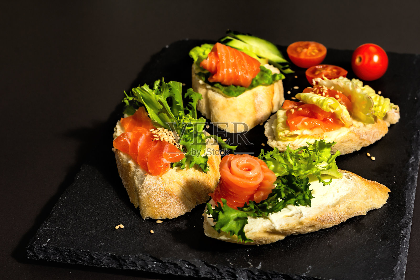 搭配咸鲑鱼、奶油芝士、沙拉叶和黄瓜的开放式三明治。海鲜照片摄影图片