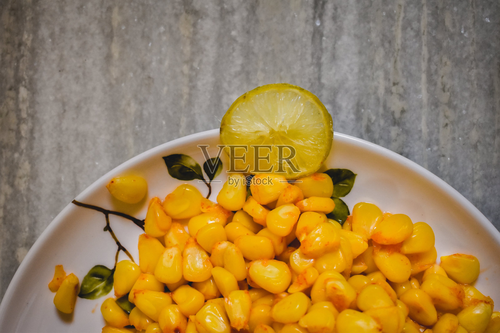 近距离拍摄在盘子里煮熟的玉米种子。照片摄影图片