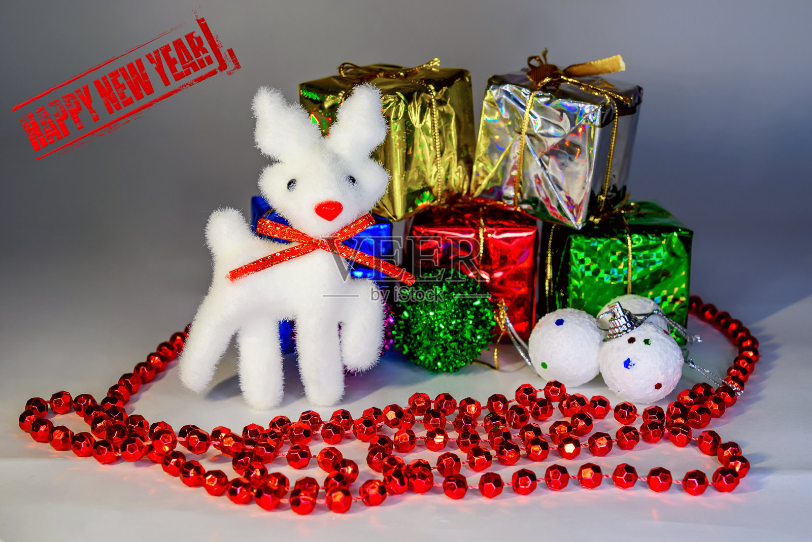 圣诞玩具以一只雪鹿的形式在背景上装着礼物的盒子照片摄影图片