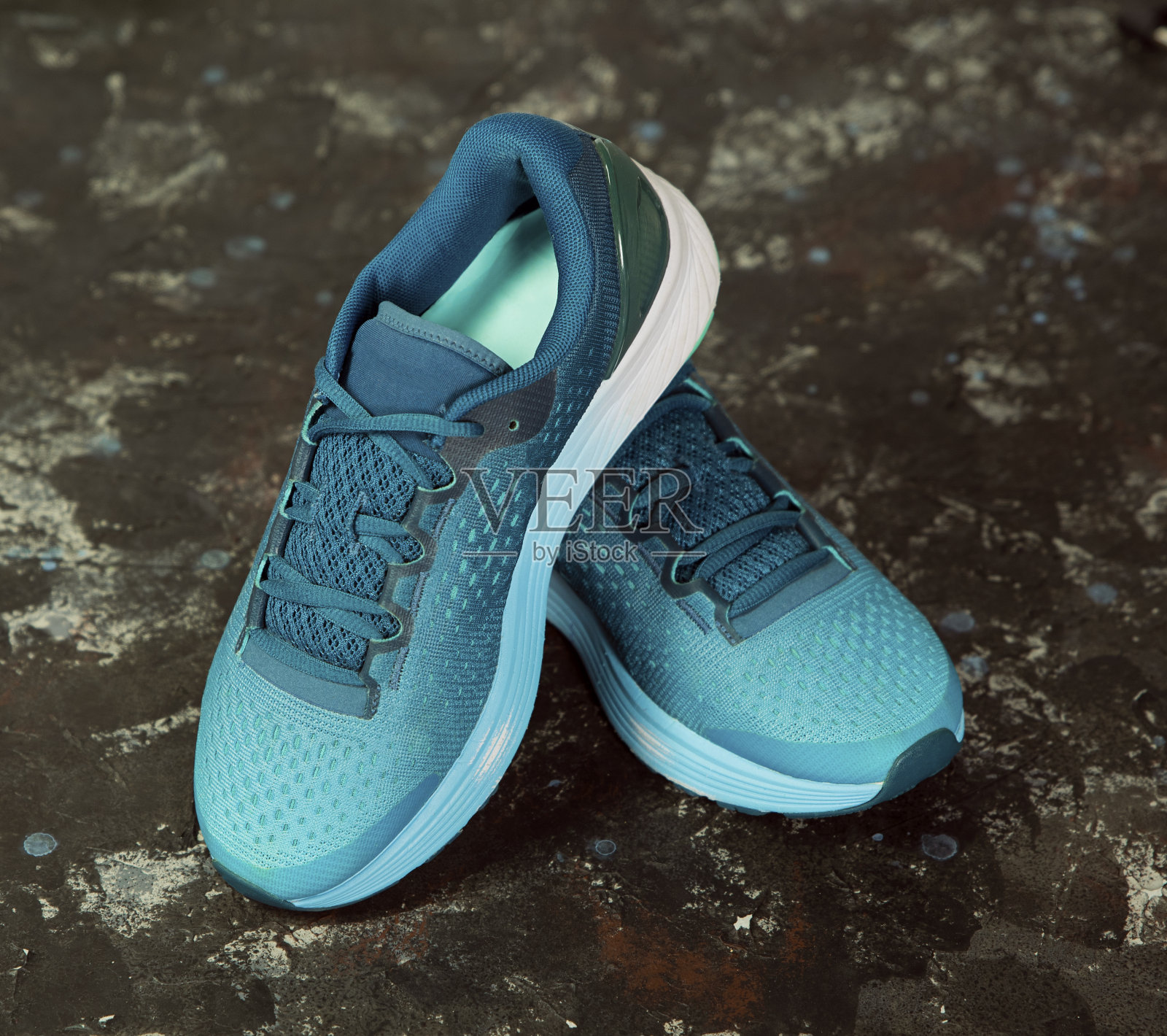 一双黑色背景的蓝色跑鞋。照片摄影图片