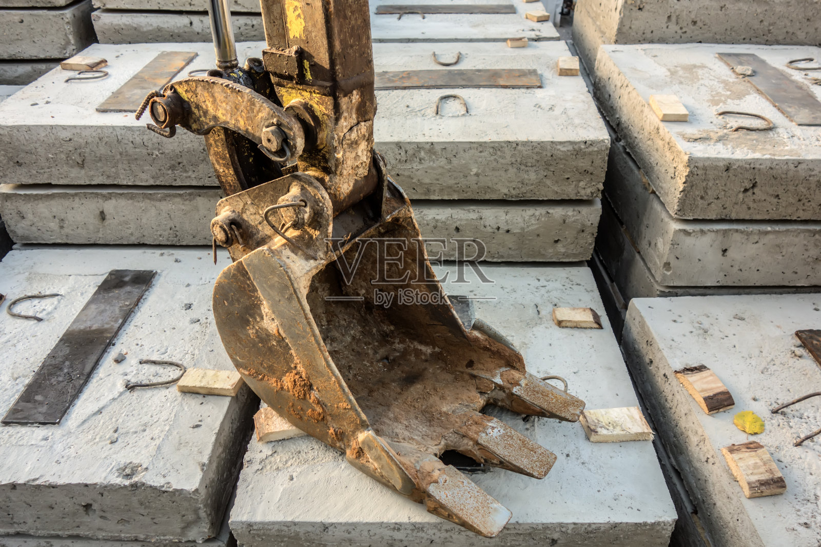 挖掘机铲斗放在混凝土块上照片摄影图片