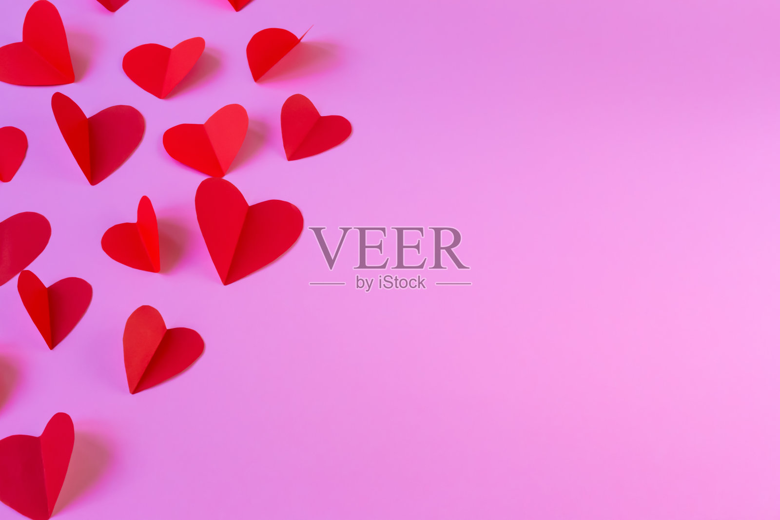 在粉红色的背景上放飞红色的心照片摄影图片