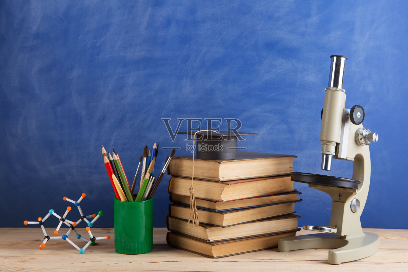 教育和科学概念——课本放在礼堂的老师桌上,黑板放在背景上。照片摄影图片