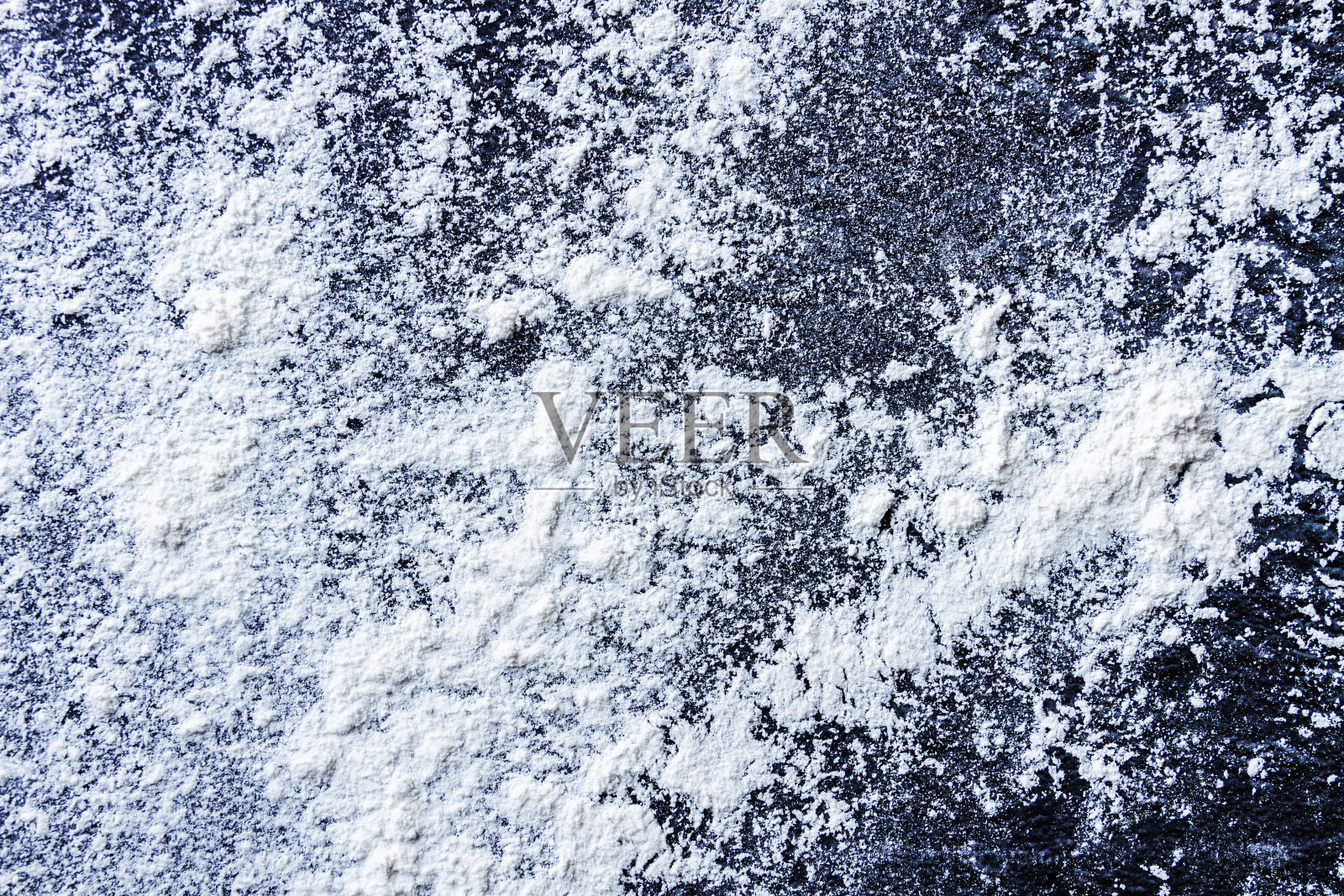 白面粉撒在有纹理的黑色桌子上照片摄影图片