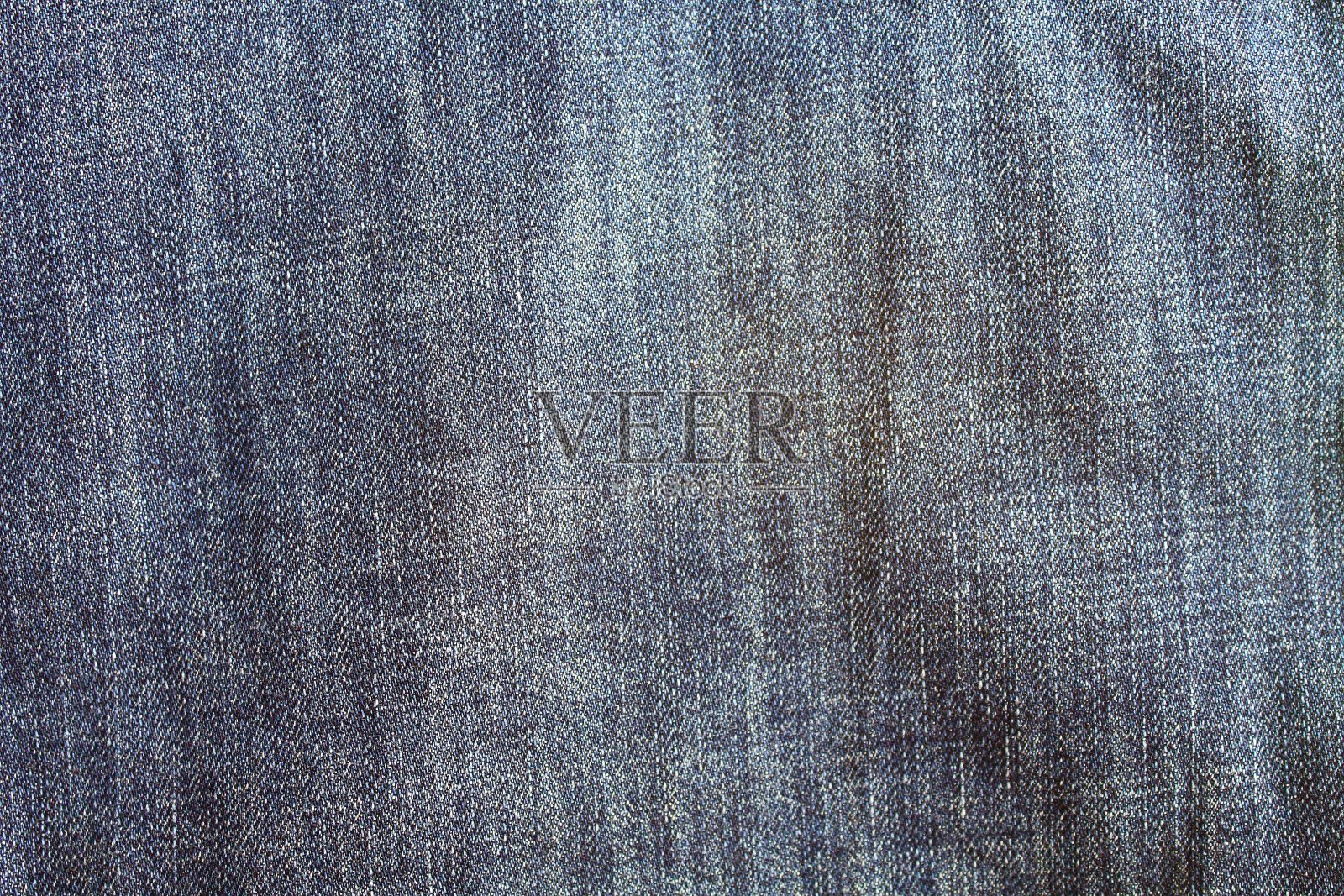 旧的蓝色褪色皱巴巴的牛仔裤。牛仔布。特写镜头。背景。纹理。照片摄影图片