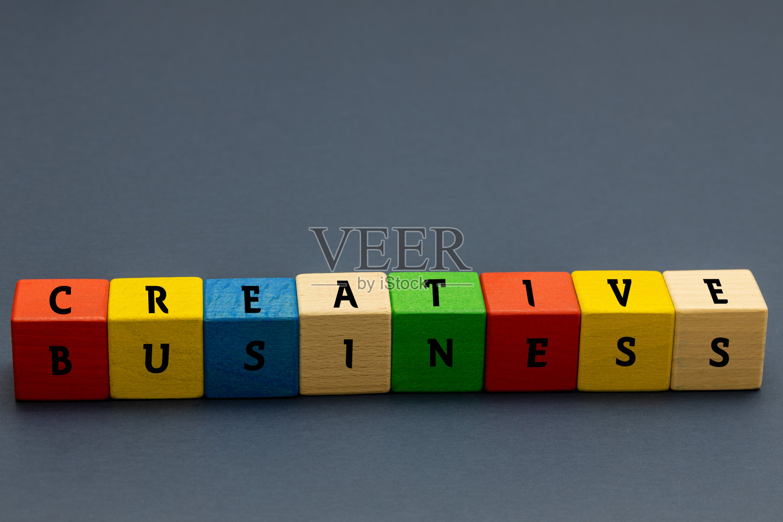 彩色的积木叠在一起,上面写着创意和商业海军蓝背景空白的空间概念创意和非传统的商业思维照片摄影图片