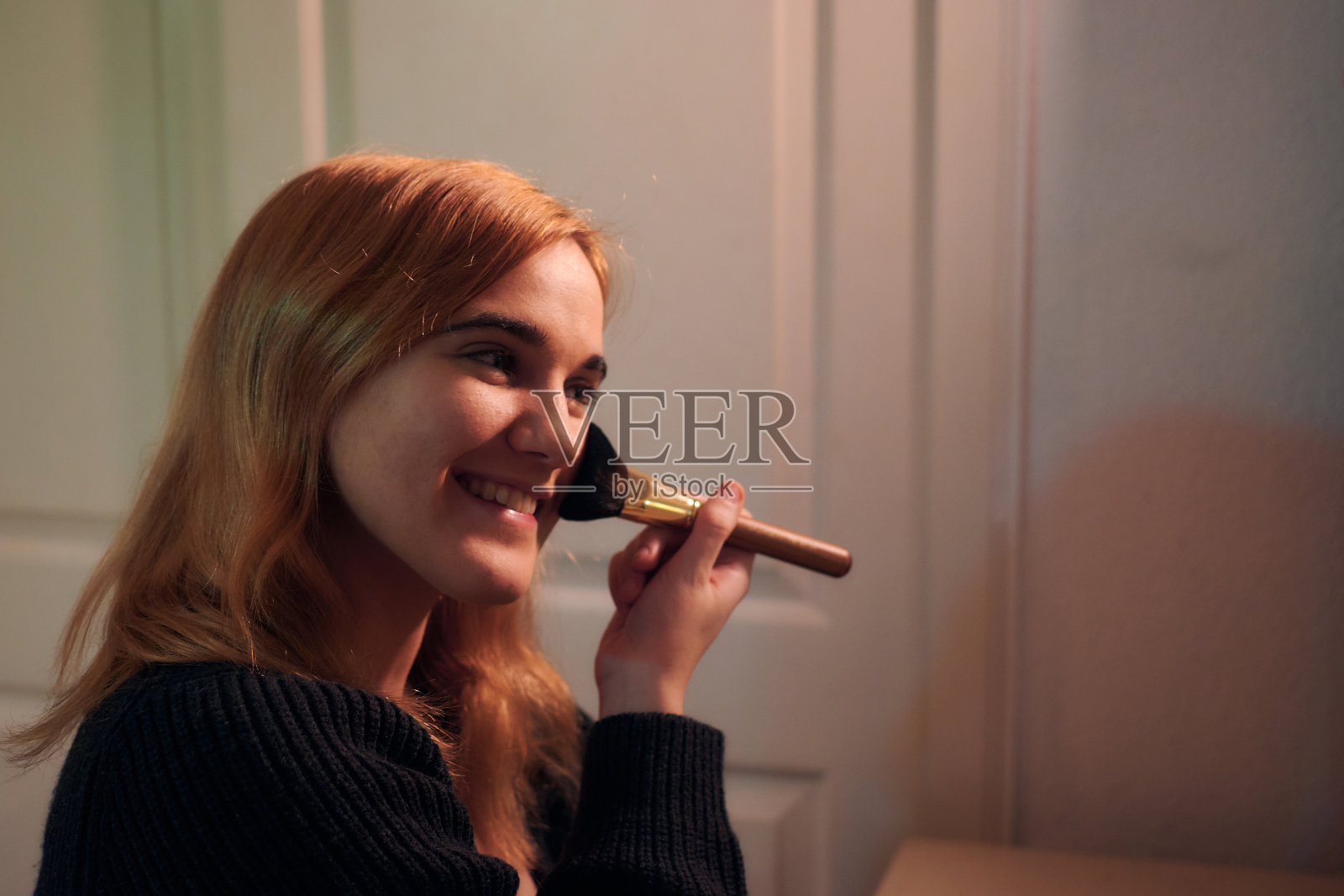 一名年轻女子在卧室的镜子前化妆照片摄影图片