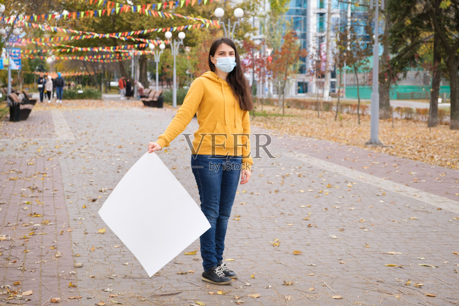 一个戴着防护面具的女人拿着一张白纸看着镜头照片摄影图片