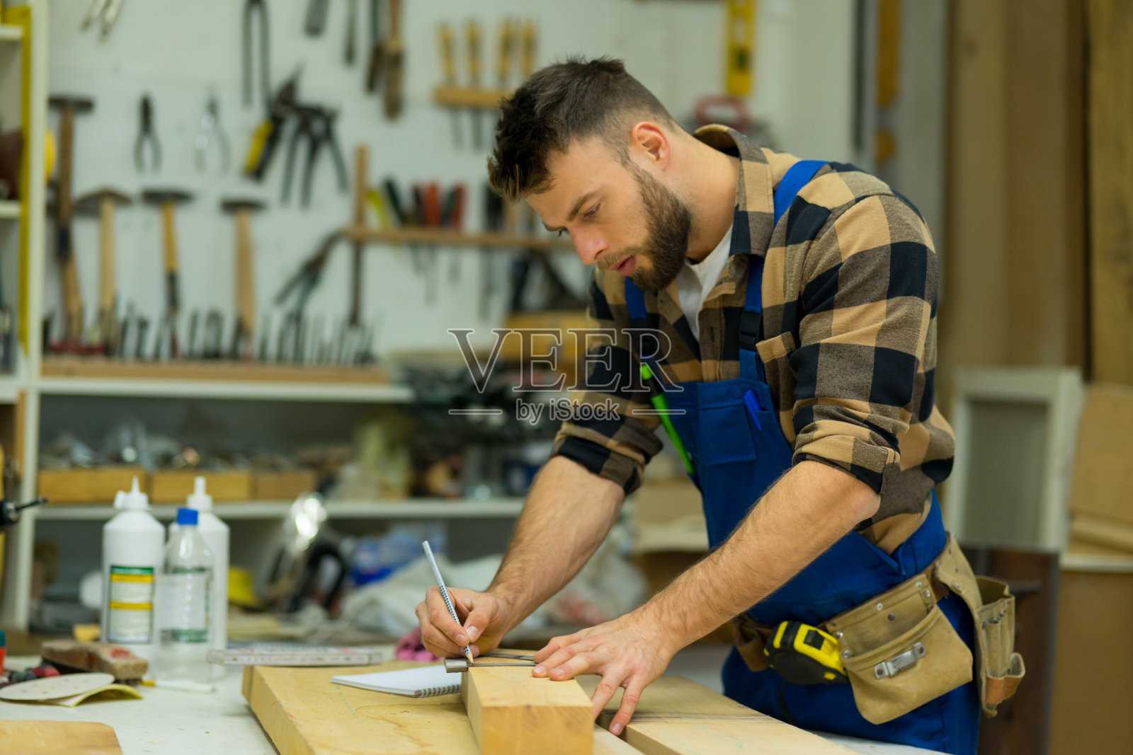 年轻的白人木匠用角尺在甲板上画画照片摄影图片