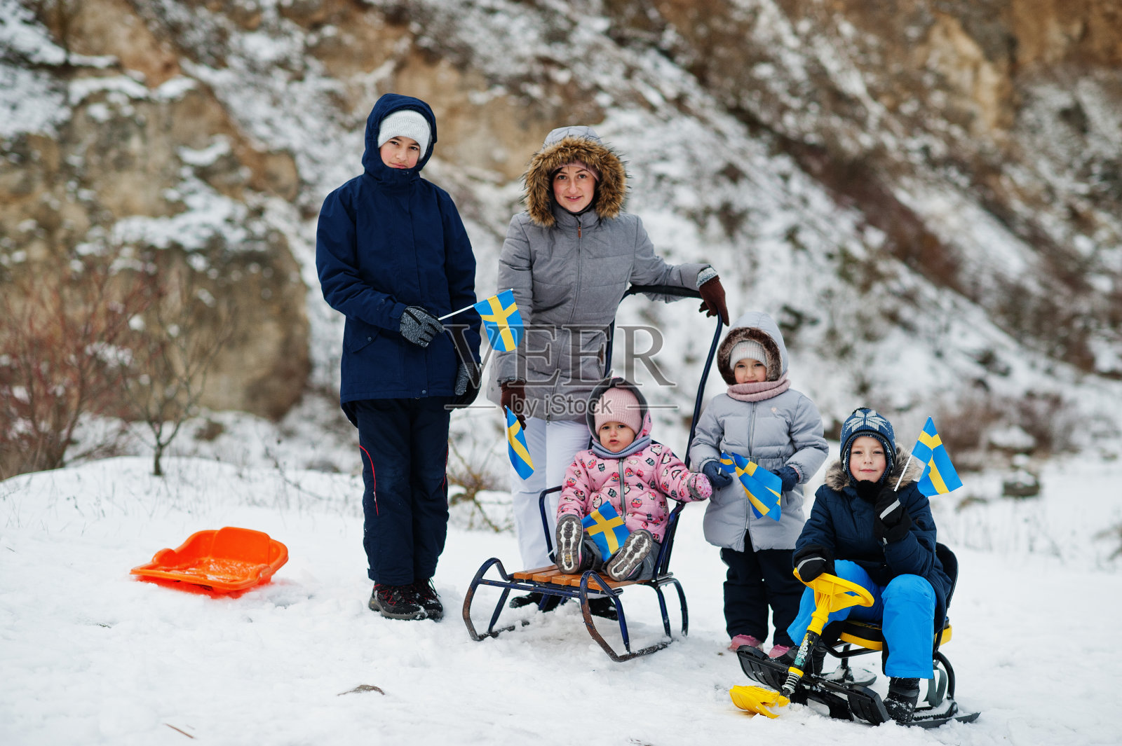 斯堪的纳维亚家庭与瑞典国旗在冬季瑞典景观。照片摄影图片