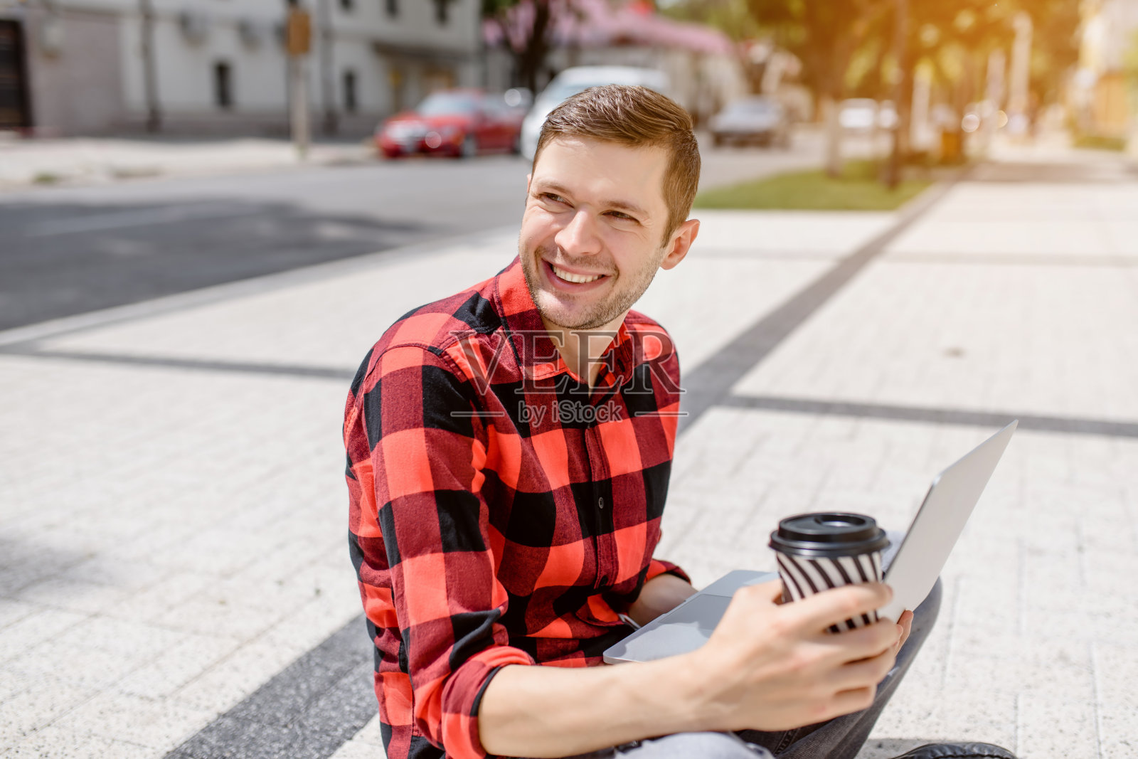一个年轻的自由职业者正在户外用他的笔记本电脑工作照片摄影图片