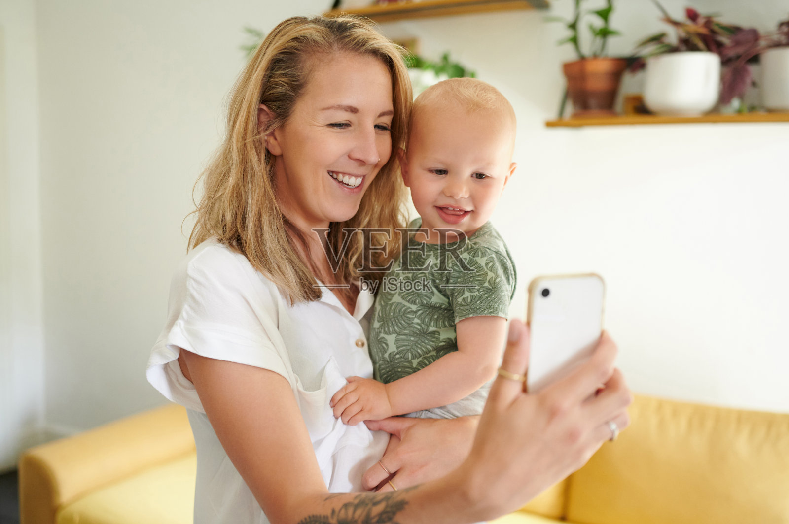 一名漂亮的年轻女子和她的儿子在家里自拍照片摄影图片