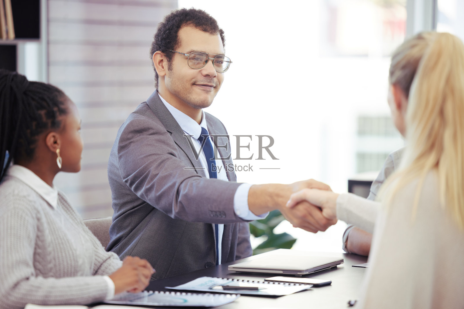 商务人士在办公室开会时握手的照片照片摄影图片