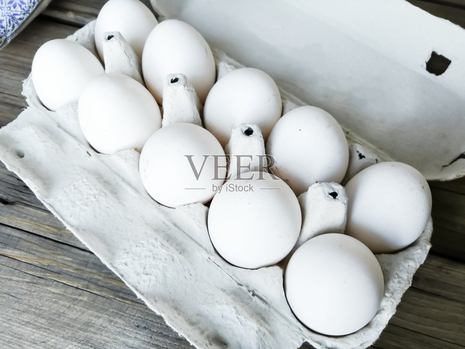 在托盘里自制的鸡蛋。木桌上的托盘里有10个鸡蛋。肮脏的鸡蛋。白色的蛋壳。照片摄影图片