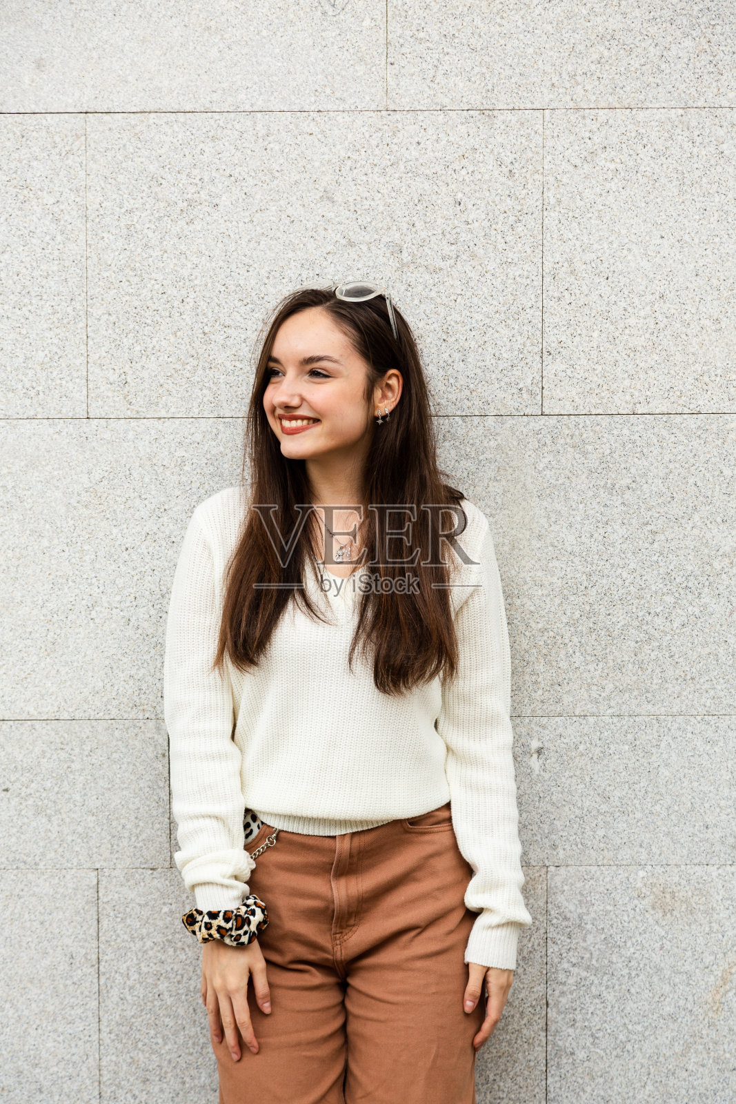 微笑的女孩靠在墙上照片摄影图片