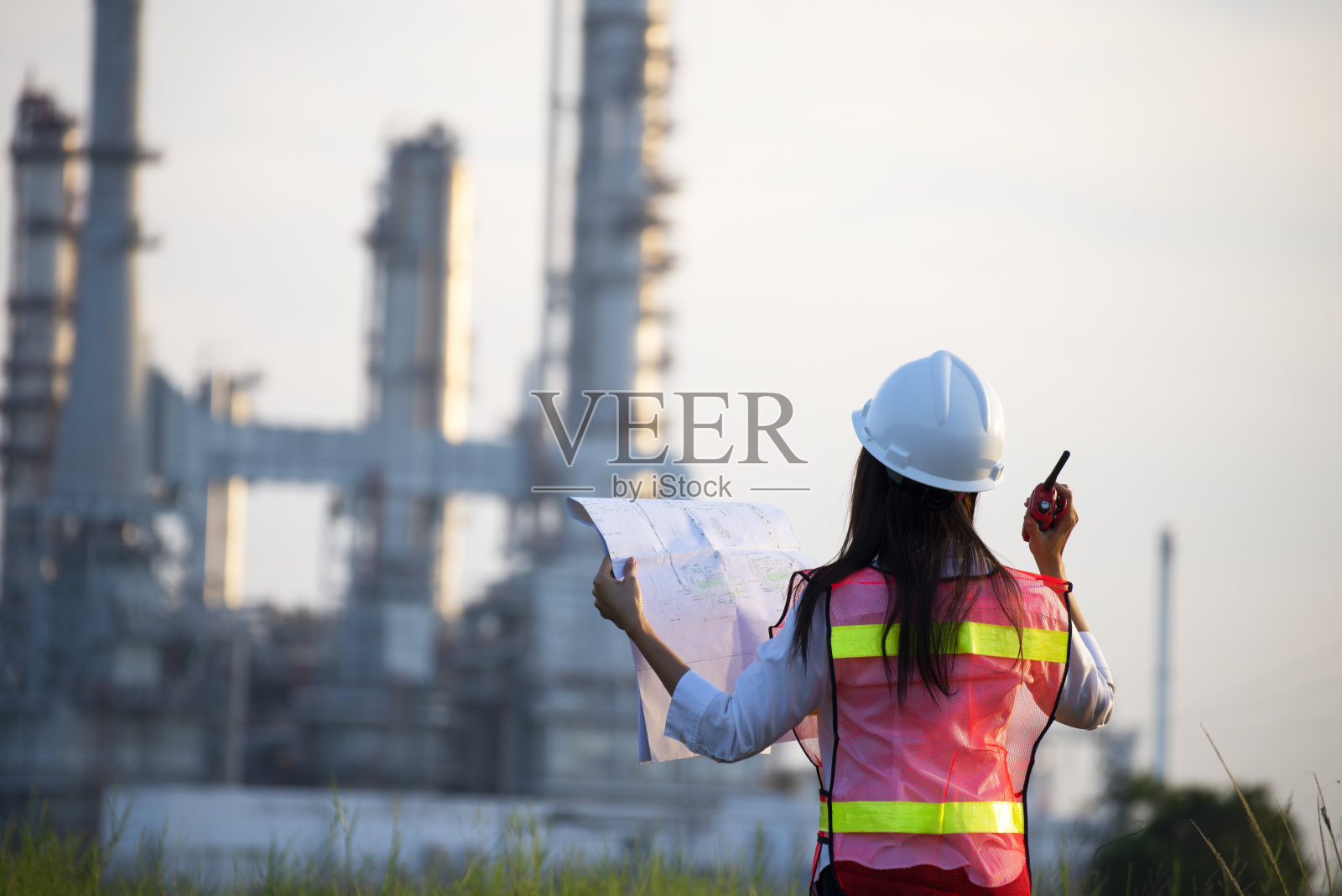 戴安全帽的经理在工厂处理文件。照片摄影图片