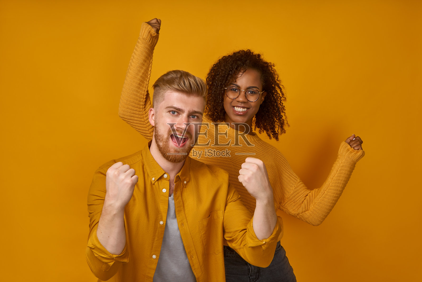 愉快的情侣紧握着拳头,像胜利者或高兴地实现了目标照片摄影图片