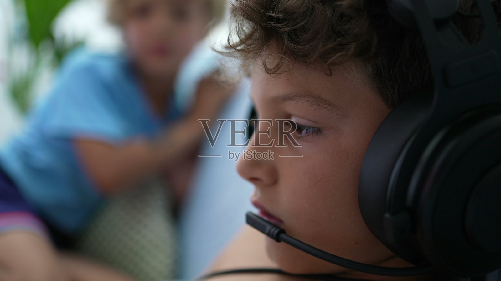 小男孩在便携式游戏机上玩电子游戏。孩子玩游戏照片摄影图片