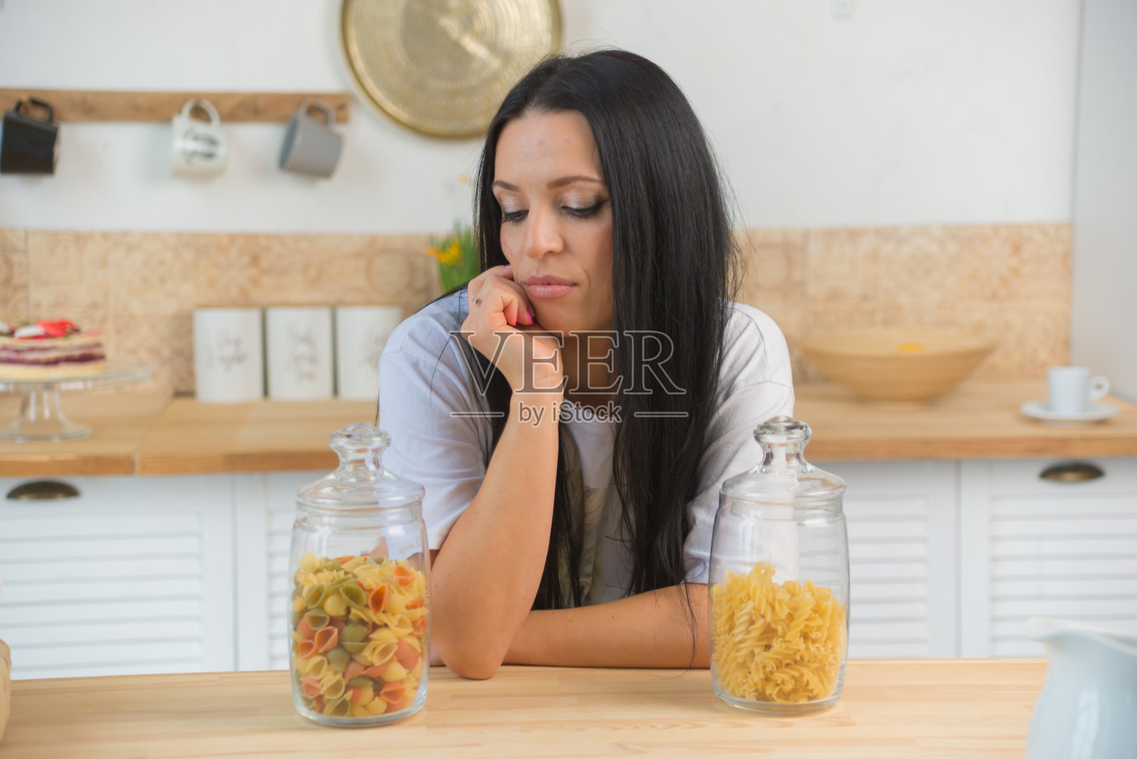 年轻的家庭主妇选择和煮意大利面在家里为全家做午餐或晚餐。照片摄影图片