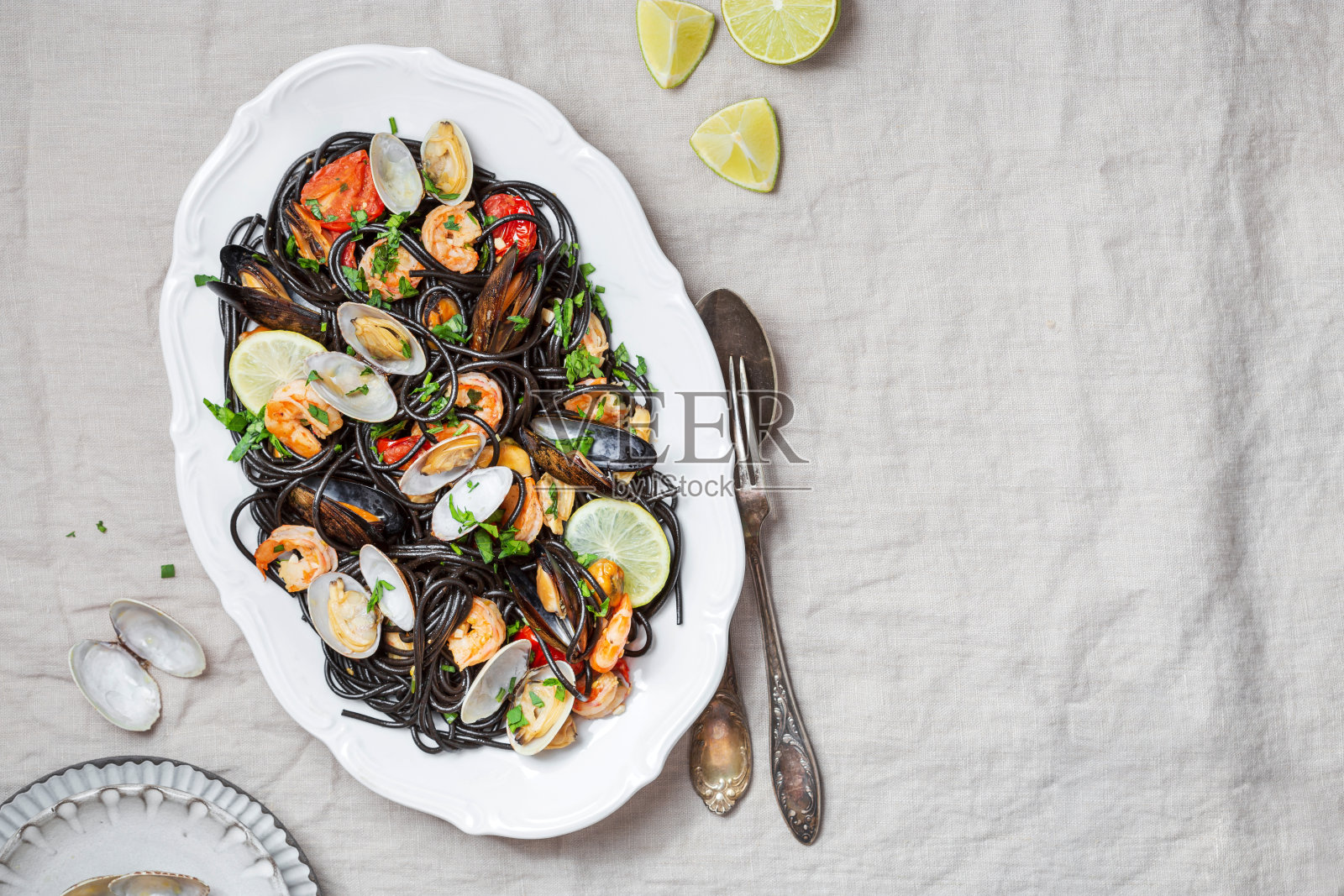 海鲜黑意大利面配蛤蜊,对虾,海扇贝照片摄影图片