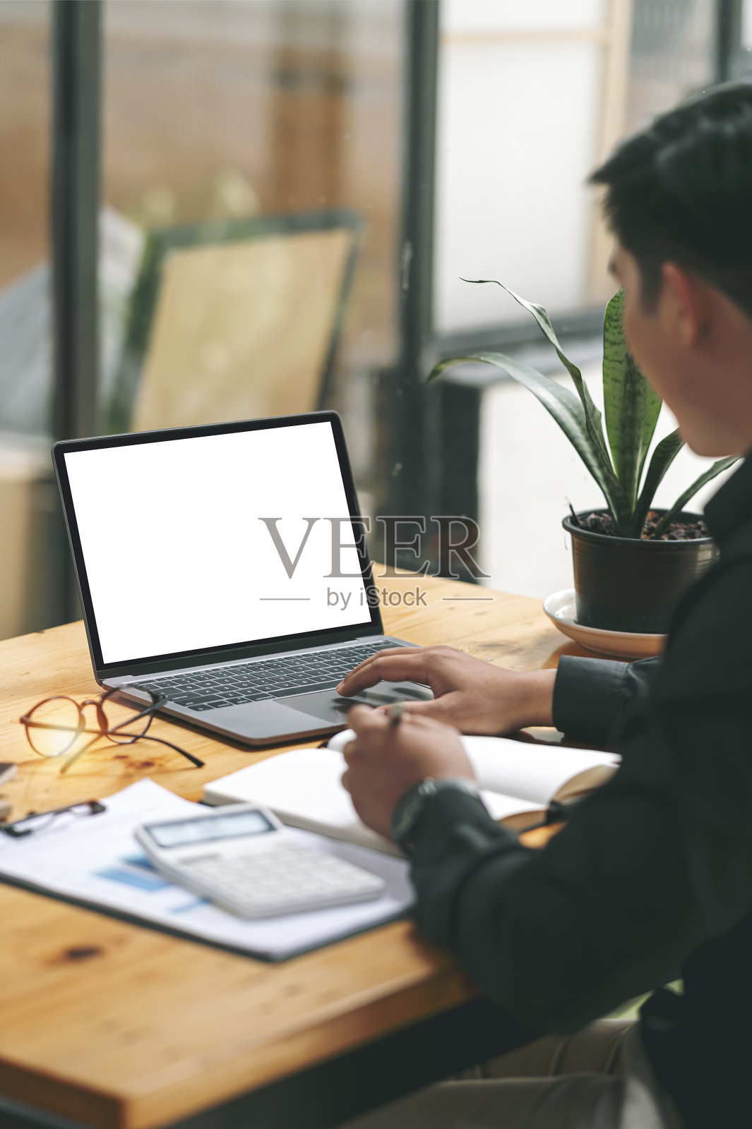 模拟图像的一个人使用笔记本电脑的空白屏幕在木制的桌子上。照片摄影图片