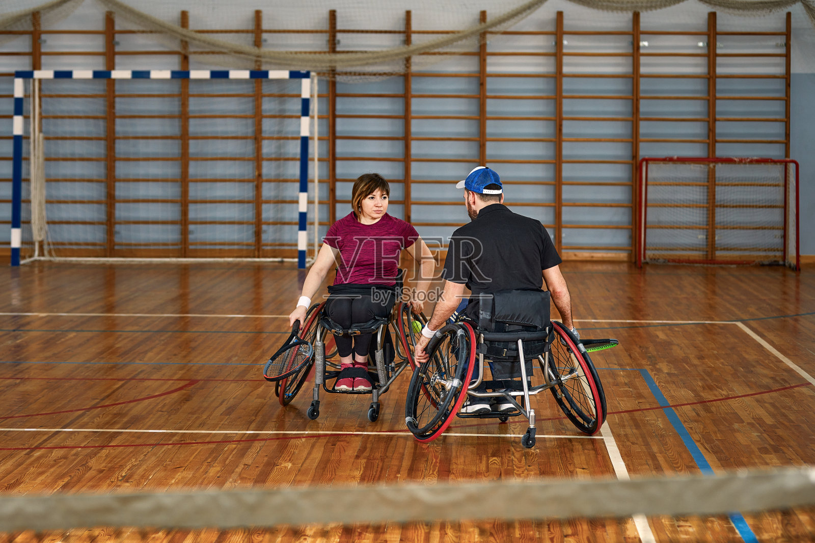 坐轮椅的人在球场上打网球。轮椅网球照片摄影图片