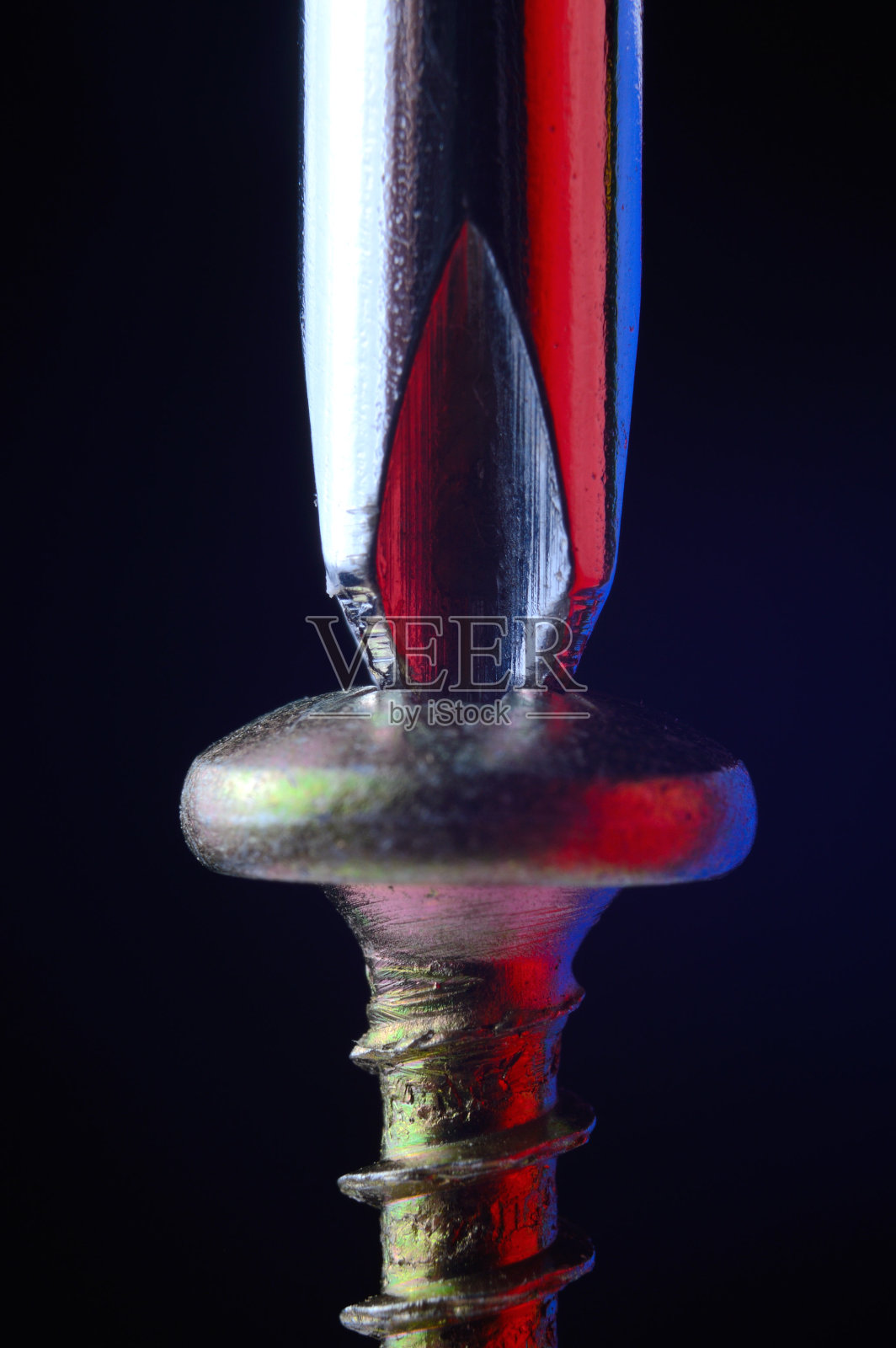 一个新的自攻螺钉和铬螺丝刀拧紧它。黑色背景的特写镜头。照片摄影图片