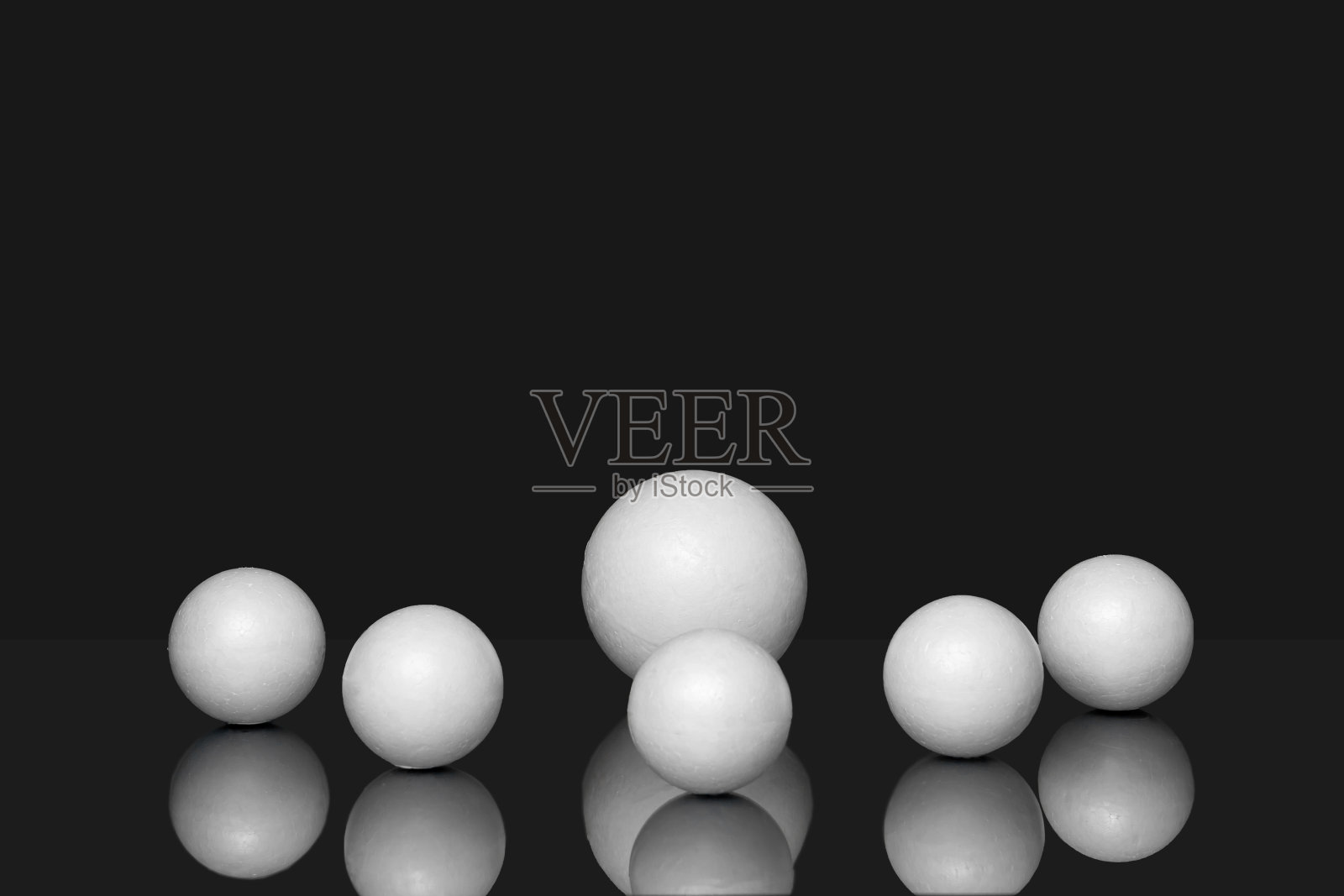 三维几何形状在黑色孤立的背景反射。白色的三维球体,大小不一,杂乱地散落在各处照片摄影图片