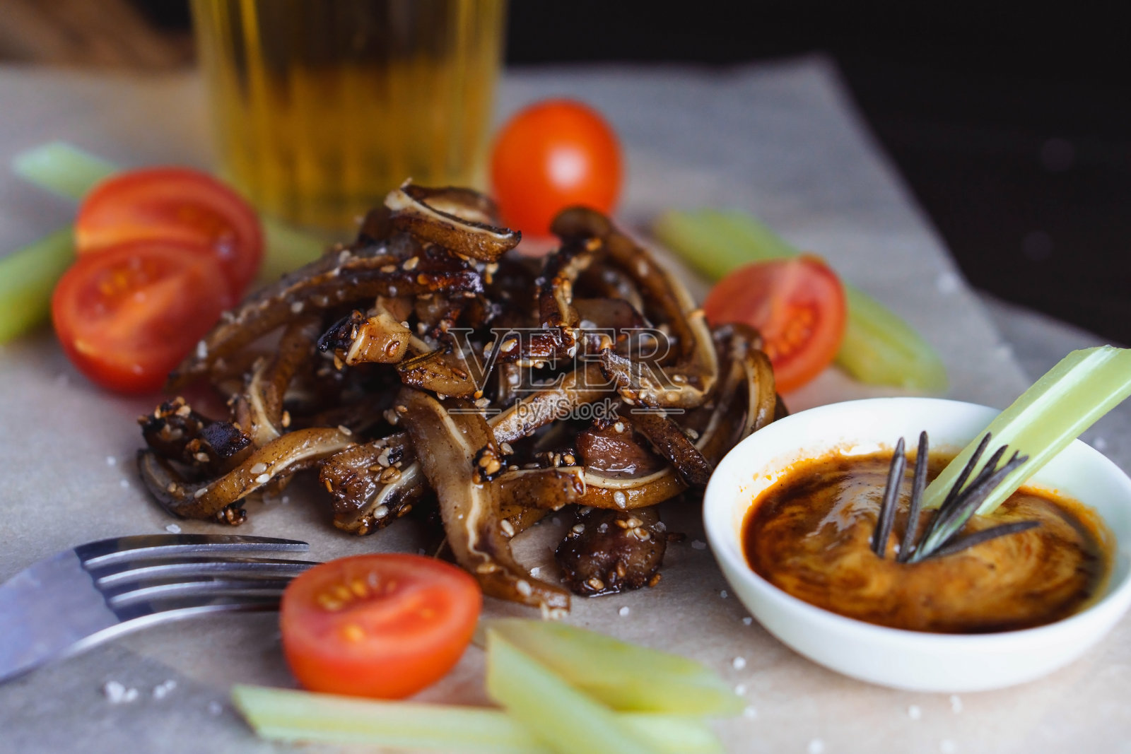 选择的重点是炸猪耳配番茄、芹菜和撒芝麻的酱汁照片摄影图片