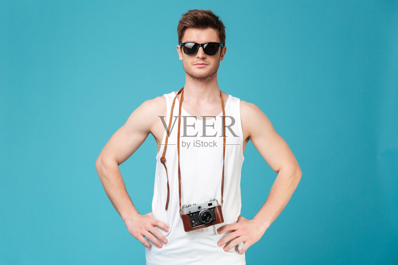 戴墨镜的男人在蓝色背景下摆出孤立的姿势照片摄影图片