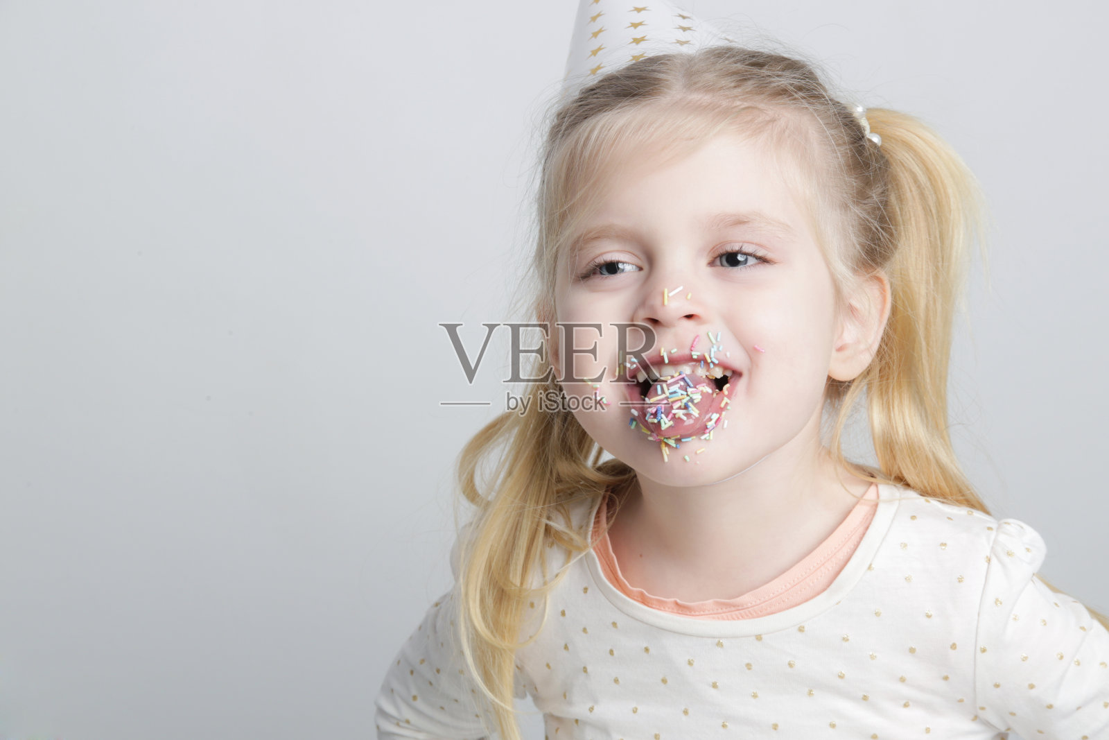 可爱的小寿星,嘴唇上和嘴里都撒着五颜六色的糖屑。儿童和糖瘾的概念。照片摄影图片