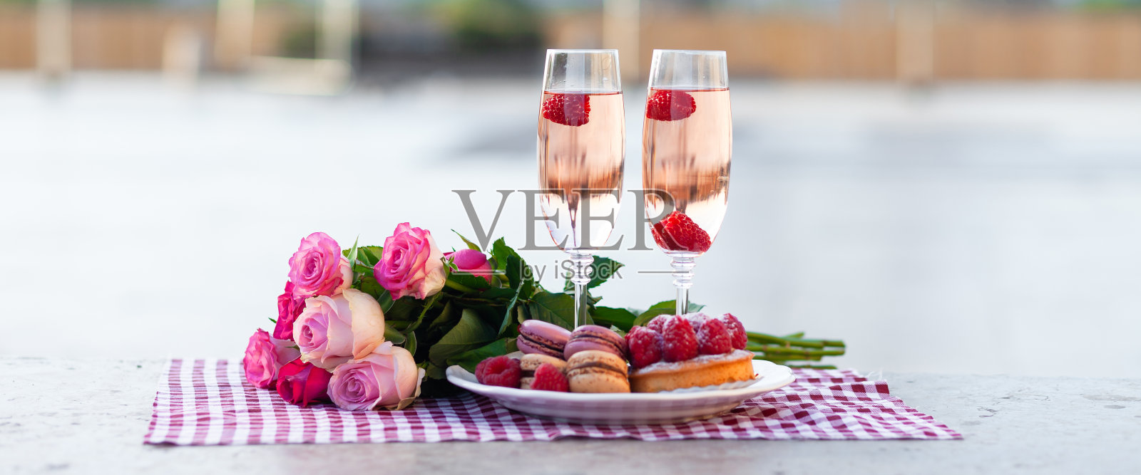 情人节浪漫求婚横幅:巴黎,爱之都,粉红玫瑰花束、两杯葡萄酒、马卡龙蛋糕,埃菲尔铁塔背景照片摄影图片