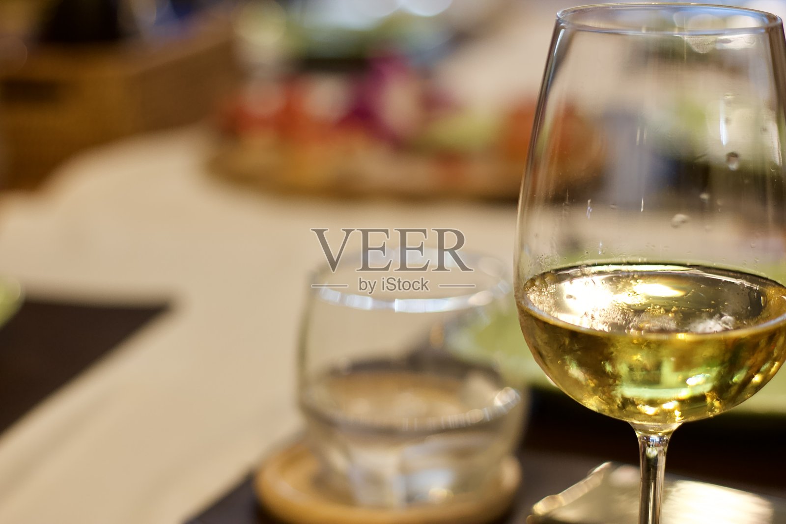 意大利餐厅餐桌上的白葡萄酒杯,在愉快的宴会概念下工作照片摄影图片