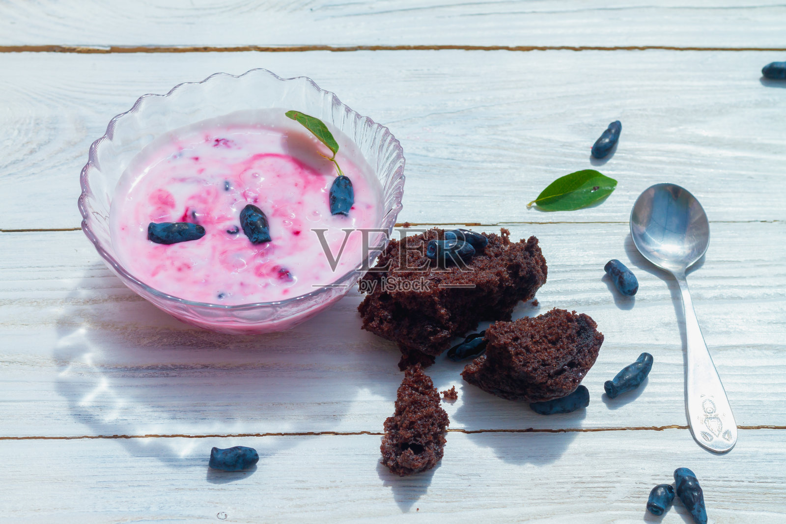 粉红色浆果酸奶与巧克力松饼和金银花浆果在白色木制背景照片摄影图片