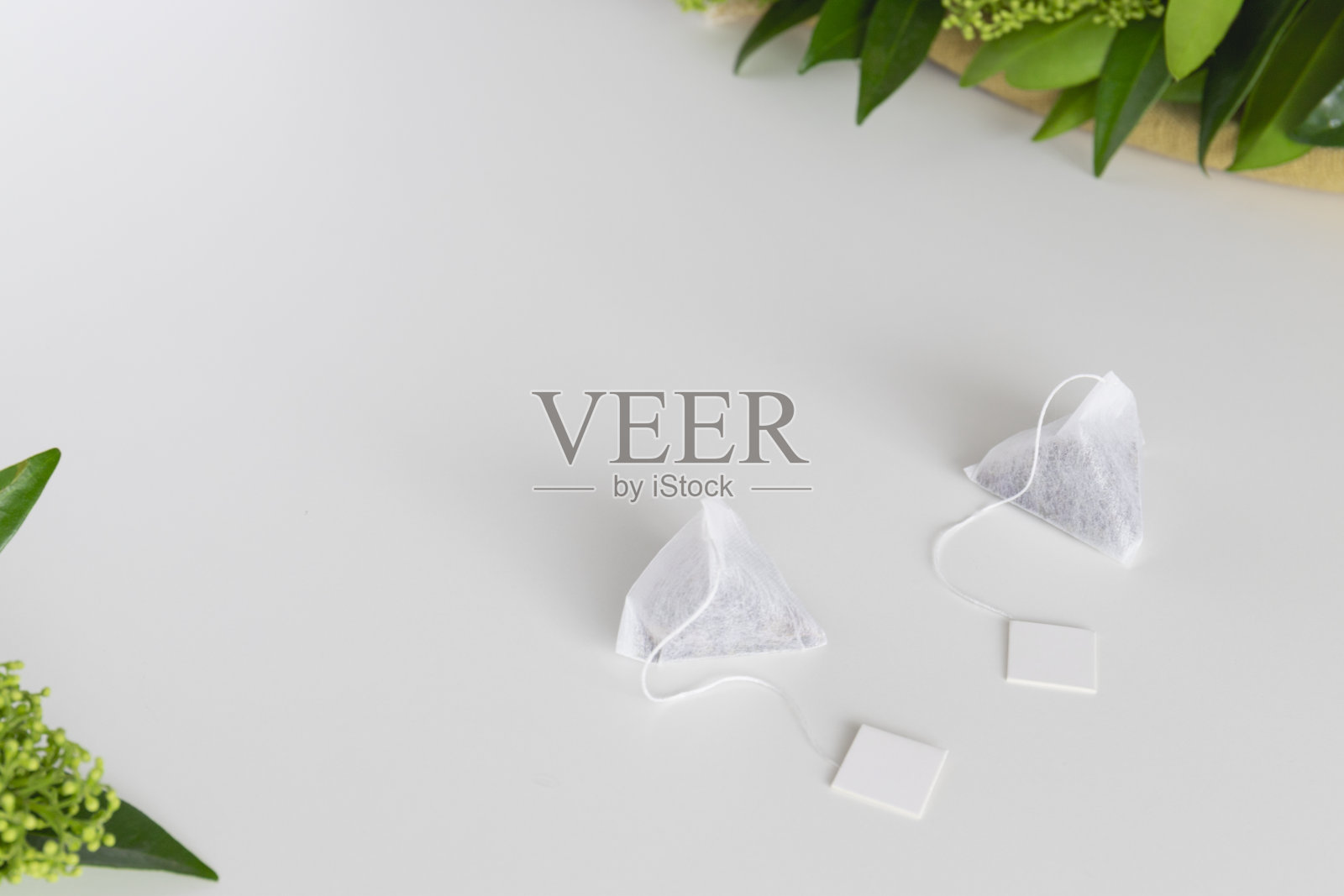 一套三角泡茶袋与标签在白色背景。空间的文本。照片摄影图片