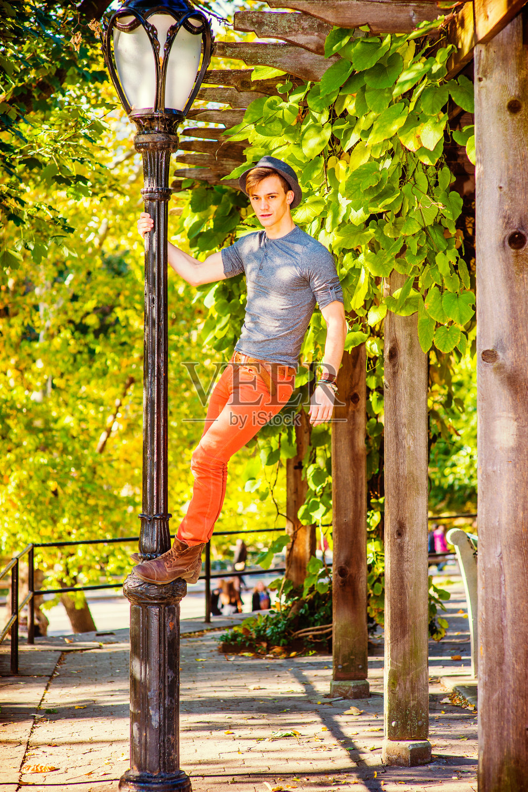 ,一个年轻的帅哥站在一根灯杆上找你。“r照片摄影图片