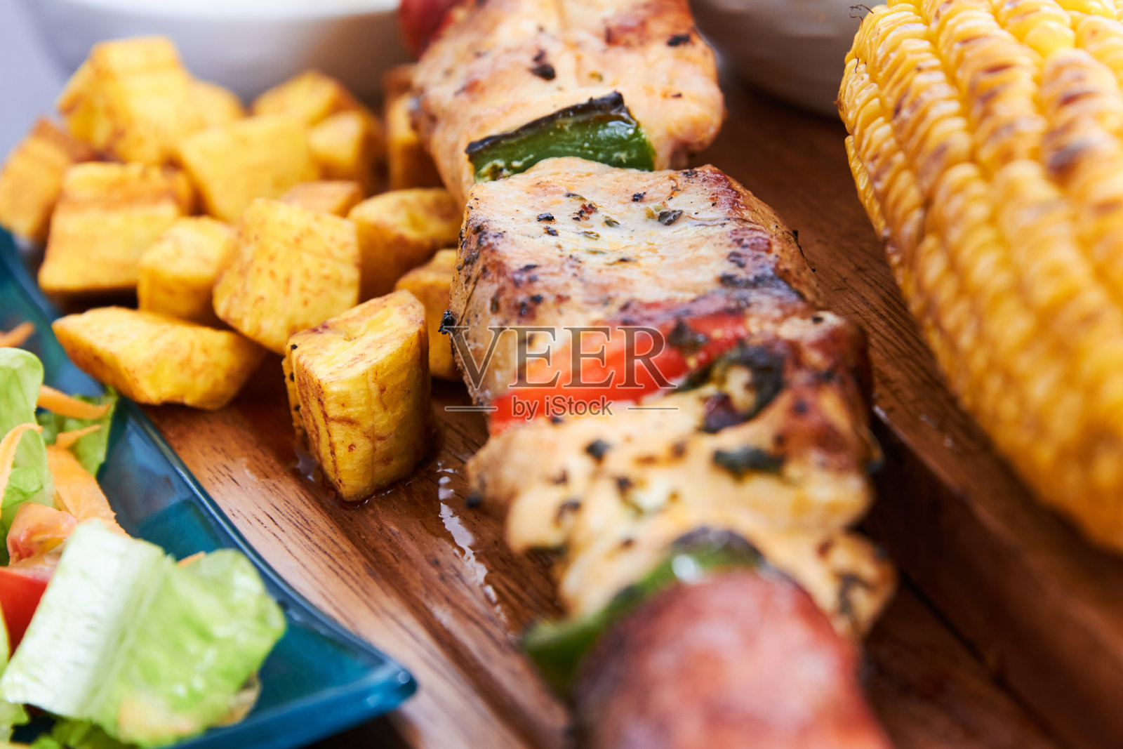 鸡串、烤玉米和炸车前草的特写镜头照片摄影图片