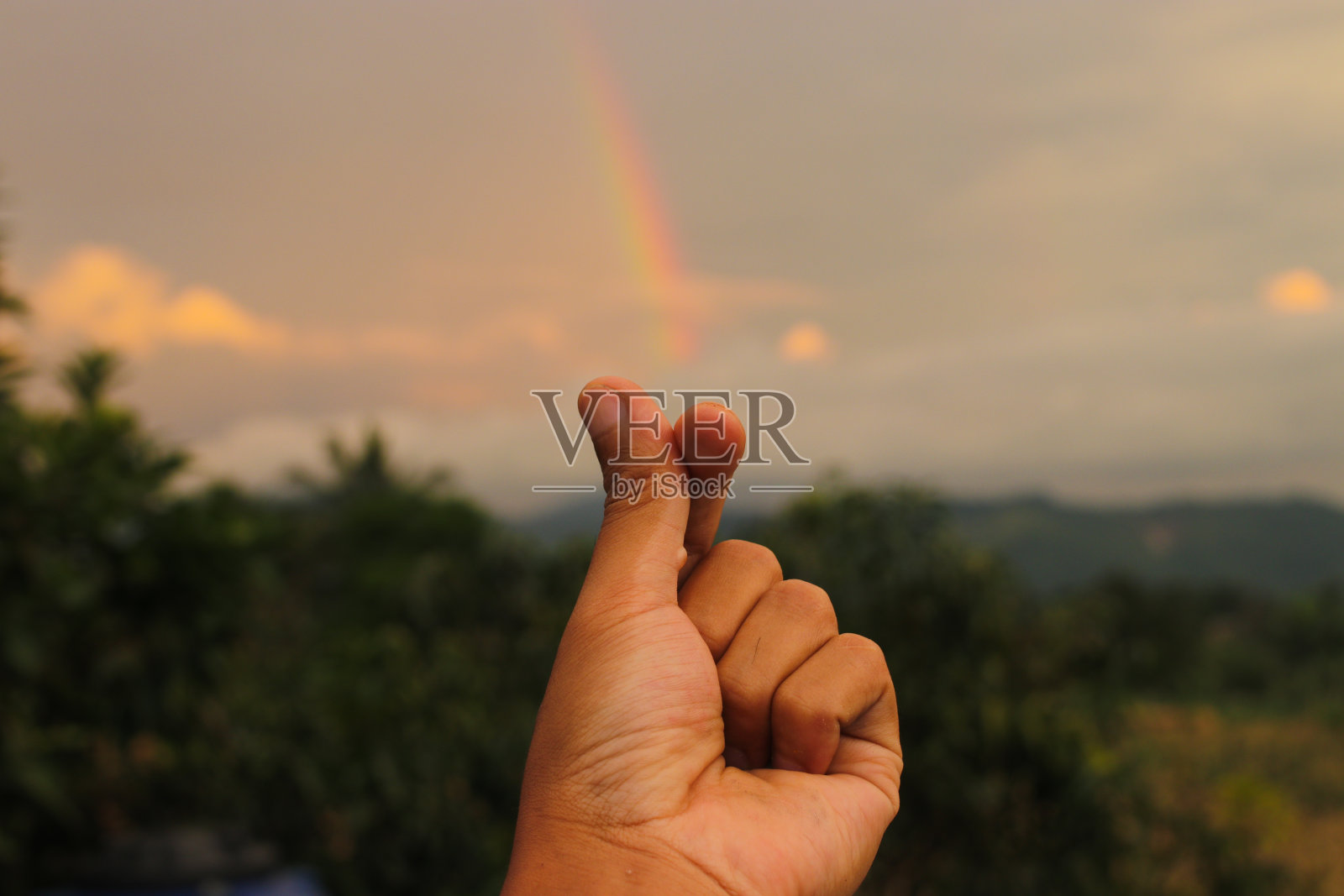 下雨后的下午,在多云的天空中用彩虹做了一个爱的标志。幸福、爱与和平的概念背景照片摄影图片