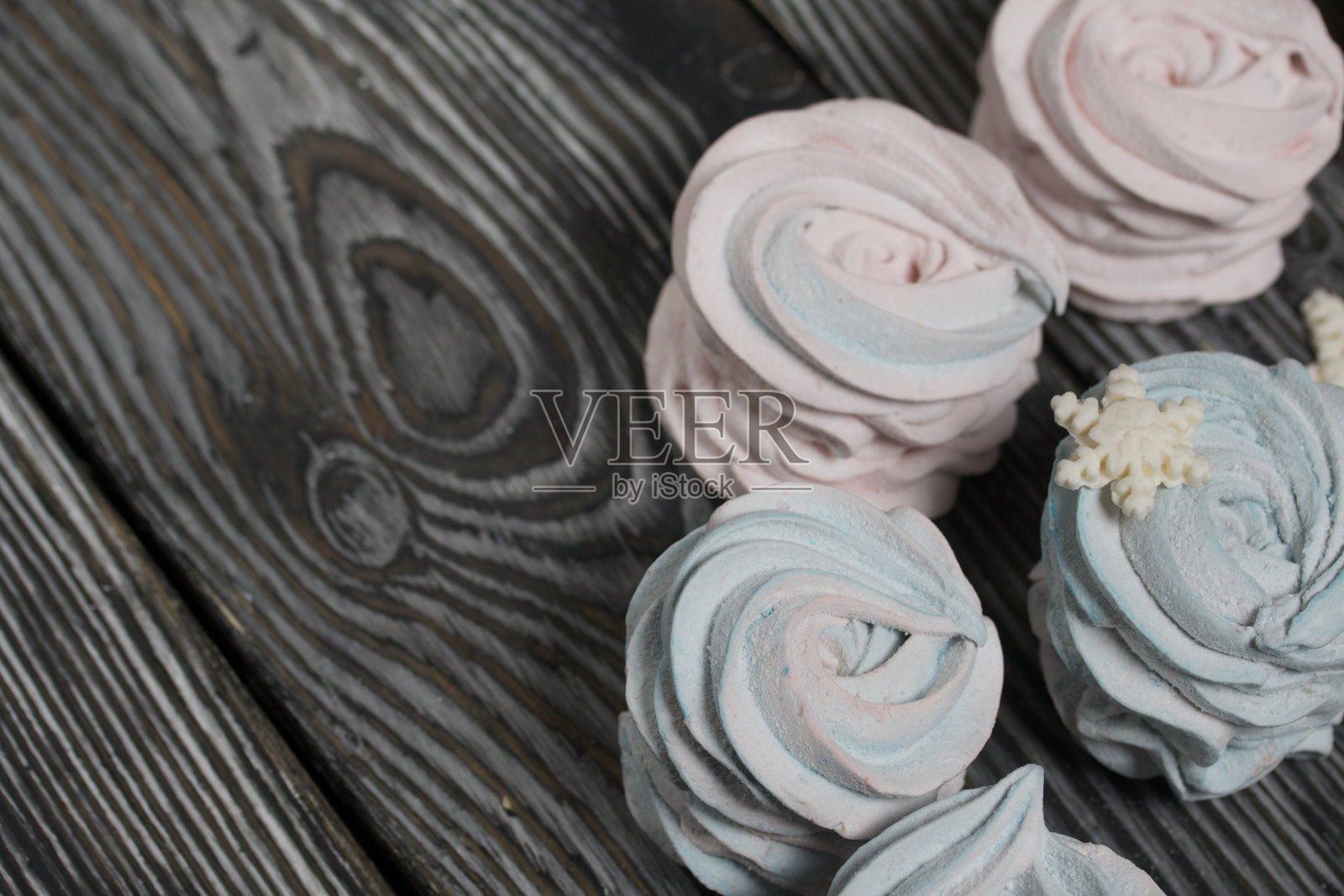 棉花糖蓝色和粉红色。用乳香雪花装饰。在黑松木板上。照片摄影图片