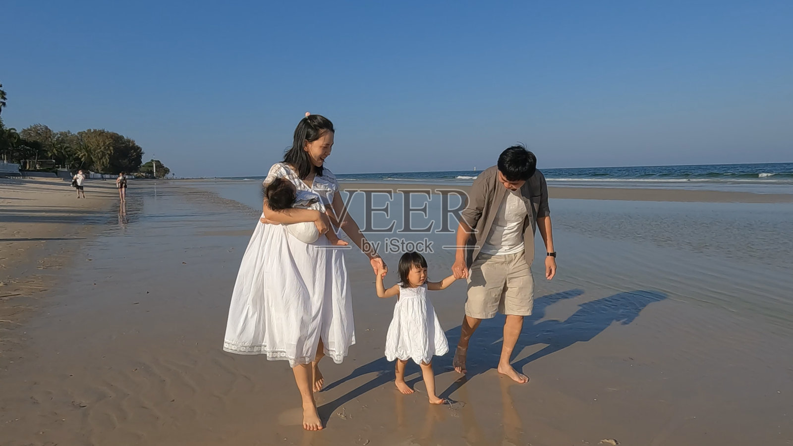 度假时一家人在海边散步。照片摄影图片