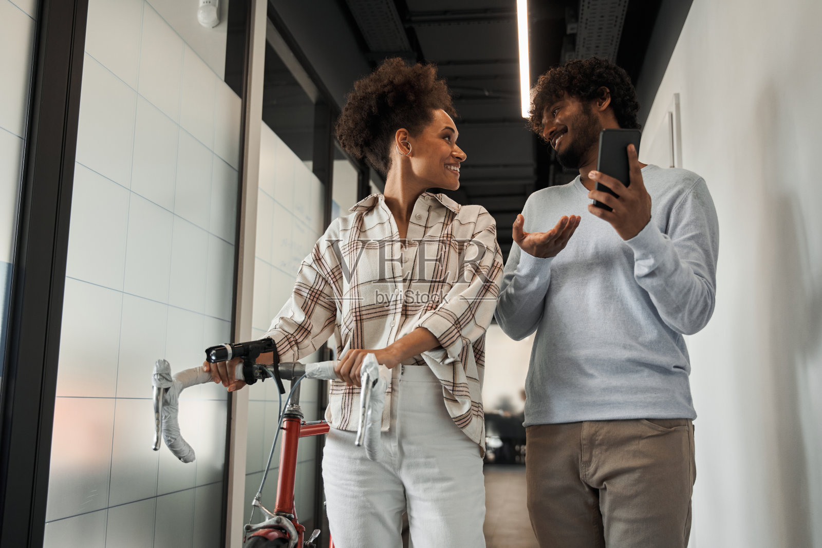 多种族同事骑着自行车穿过大厅照片摄影图片