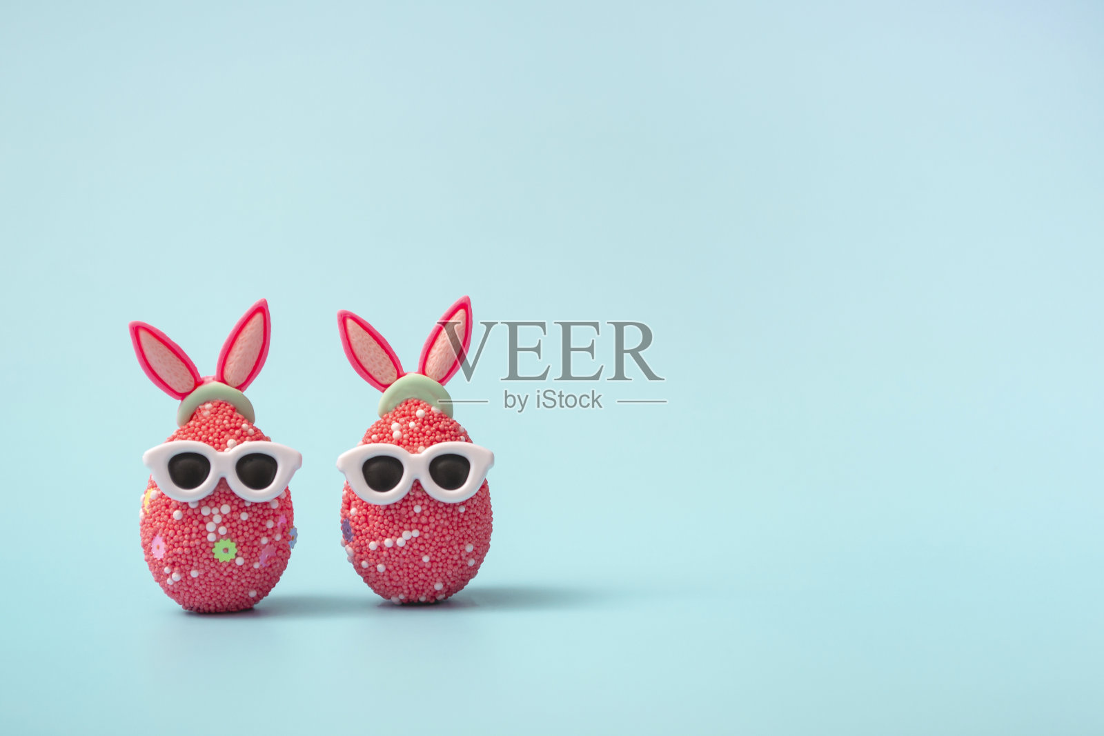 色彩丰富的复活节彩蛋与兔子耳朵和太阳镜在蓝色的背景。销售横幅,模型模板。本空间照片摄影图片