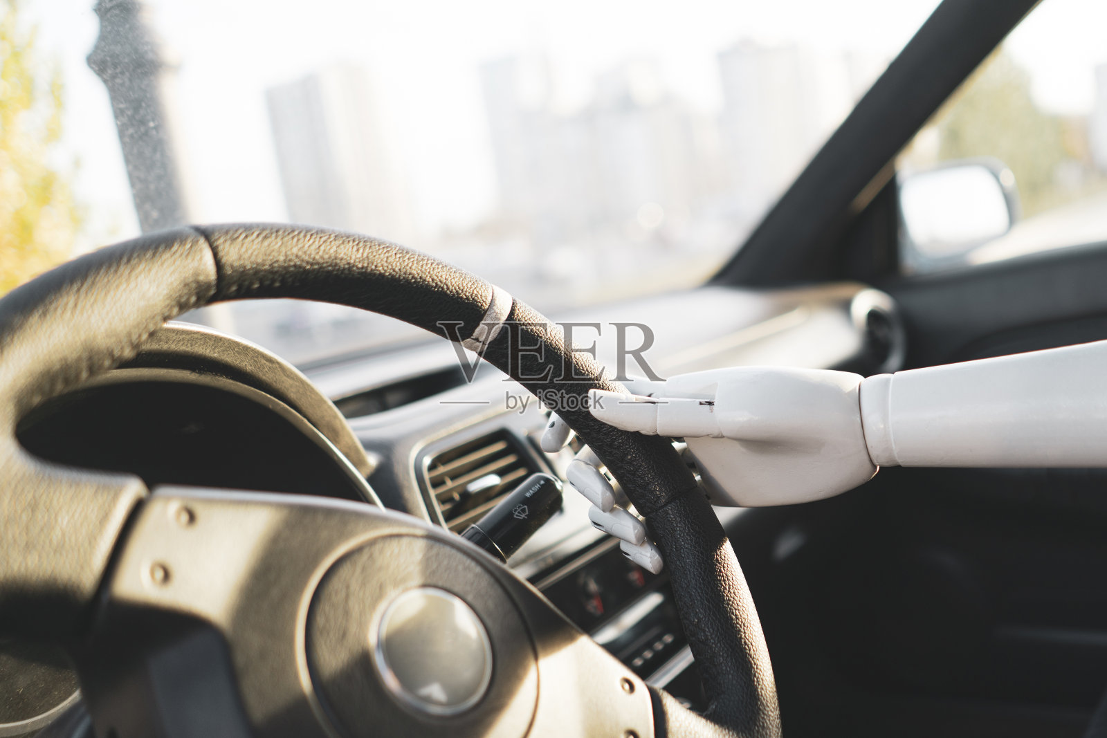 人工机械白臂握着方向盘驾驶车辆照片摄影图片