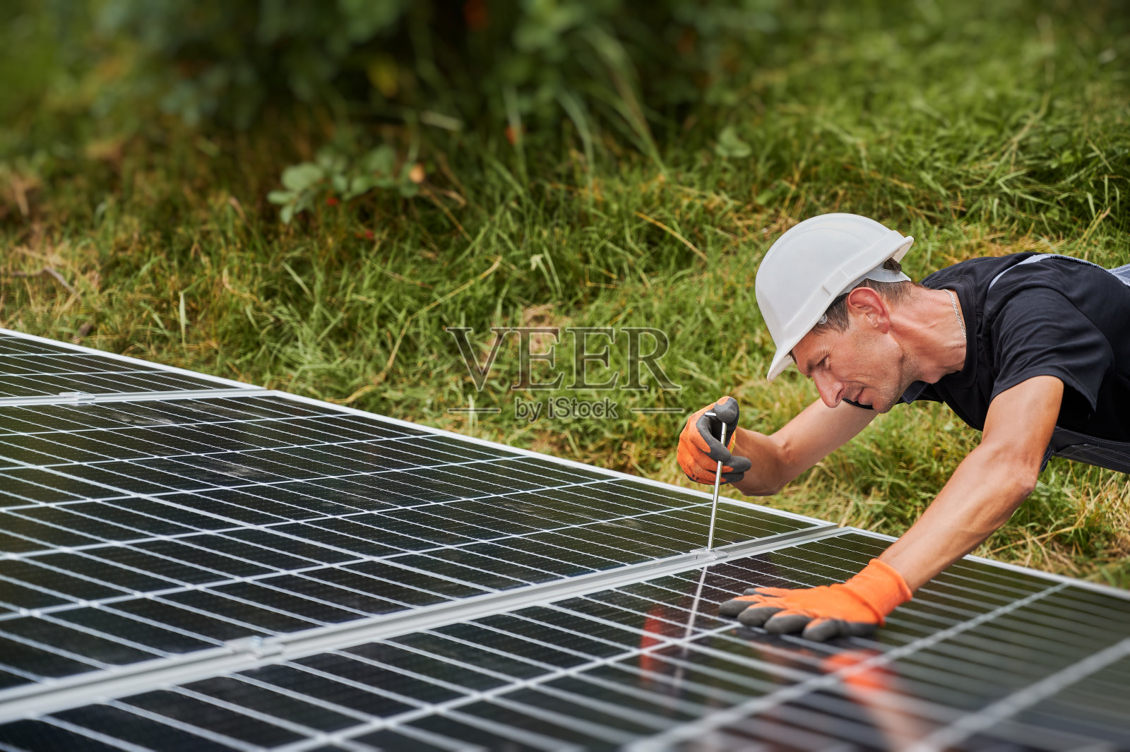 男工人在户外安装光伏太阳能电池板系统。照片摄影图片