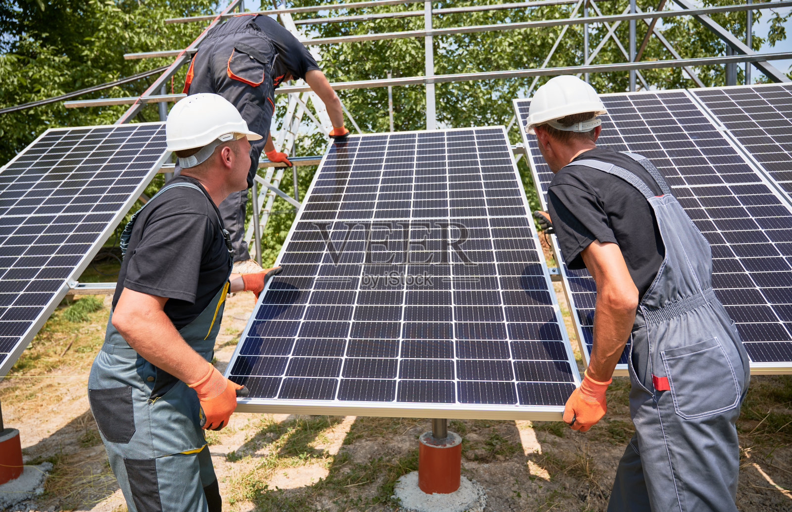安装光伏太阳能电池板系统的工人照片摄影图片