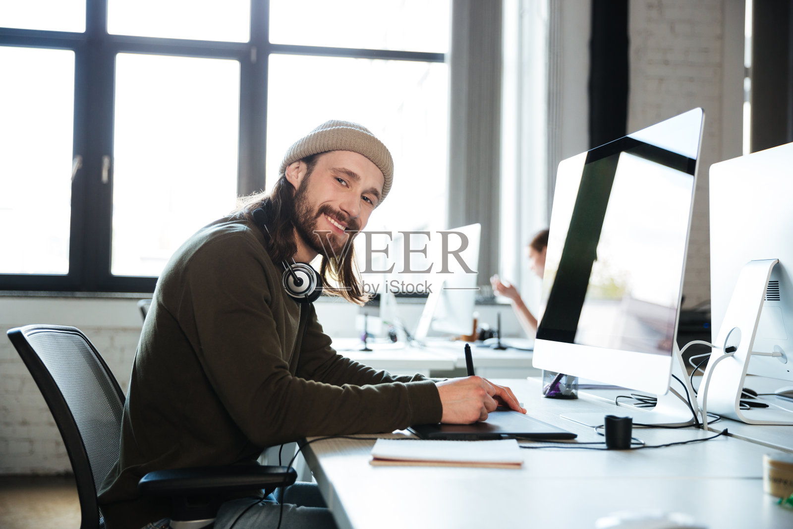 快乐的人使用电脑在办公室工作。看相机。照片摄影图片