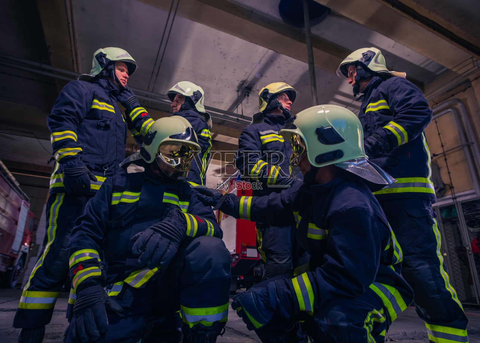消防站内,一群消防队员站在消防车前照片摄影图片