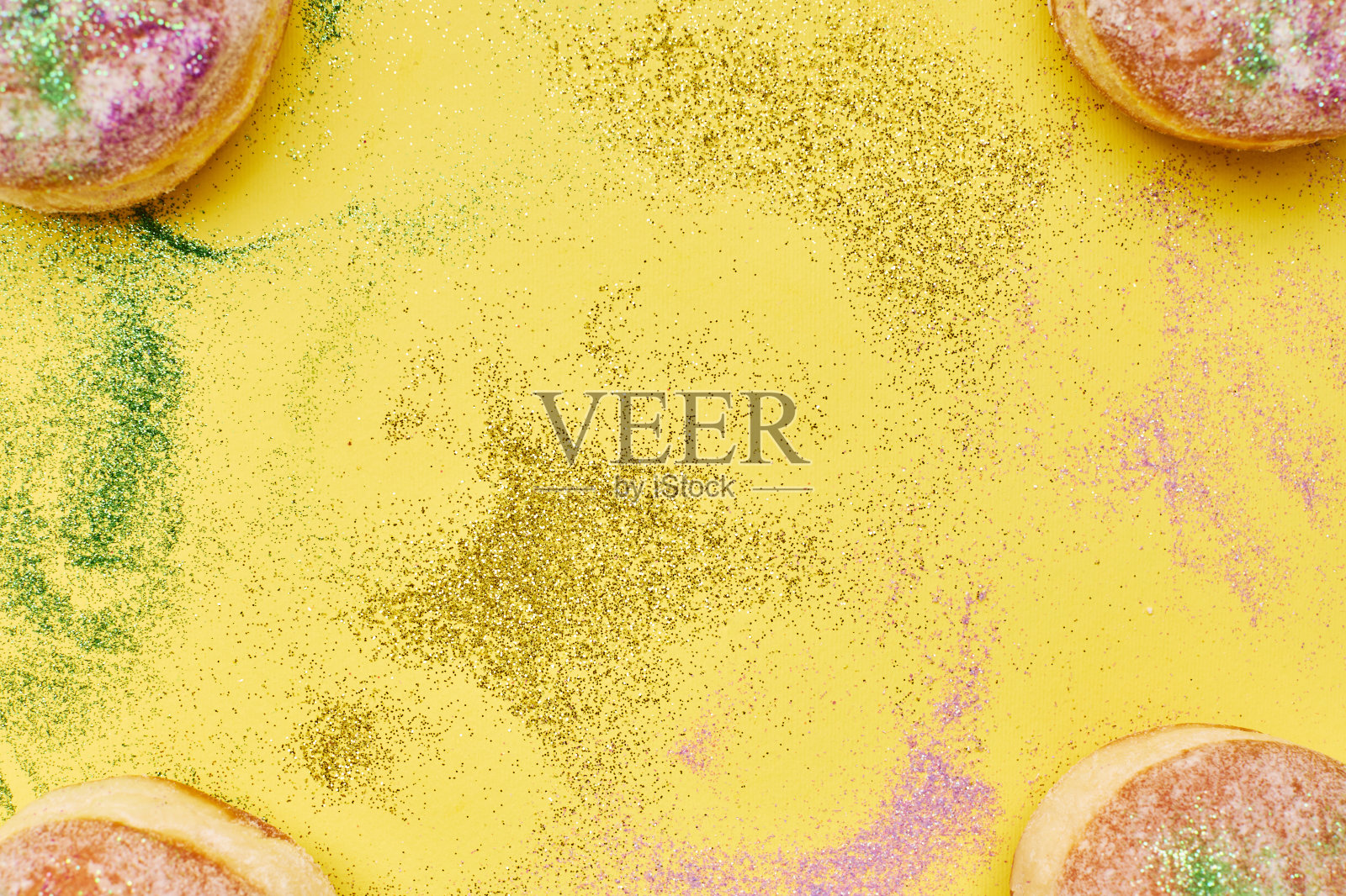 以甜甜圈和五彩纸屑为背景的狂欢节。照片摄影图片