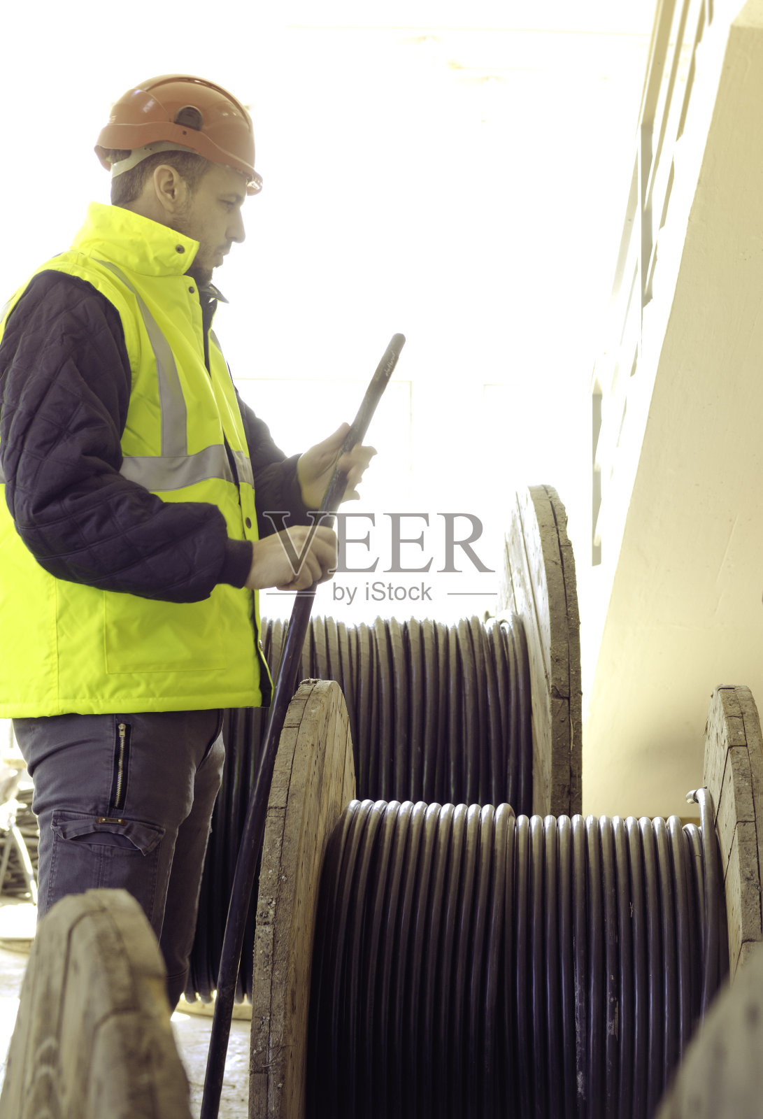 电工在高压电站与电缆滚筒一起工作。照片摄影图片